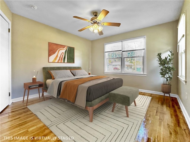 bedroom with ceiling fan, light wood-type flooring, and multiple windows