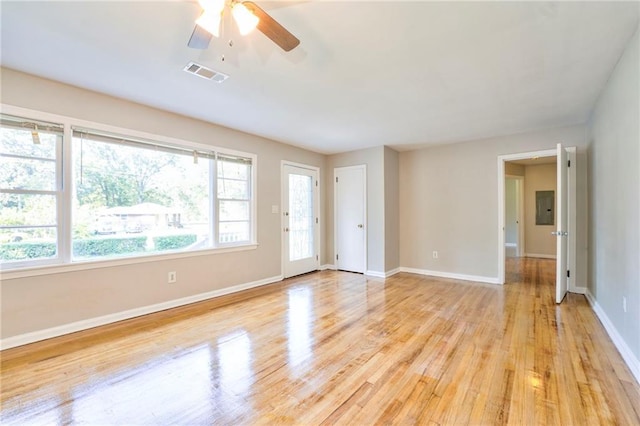 spare room with electric panel, light hardwood / wood-style flooring, ceiling fan, and a healthy amount of sunlight