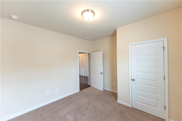 unfurnished bedroom with carpet floors and baseboards