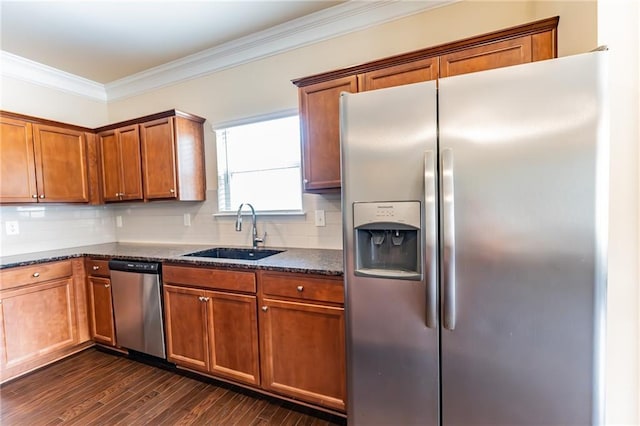 kitchen featuring ornamental molding, appliances with stainless steel finishes, a sink, and tasteful backsplash