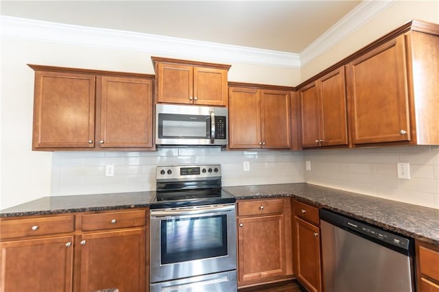 kitchen with brown cabinets, stainless steel appliances, tasteful backsplash, ornamental molding, and dark stone counters