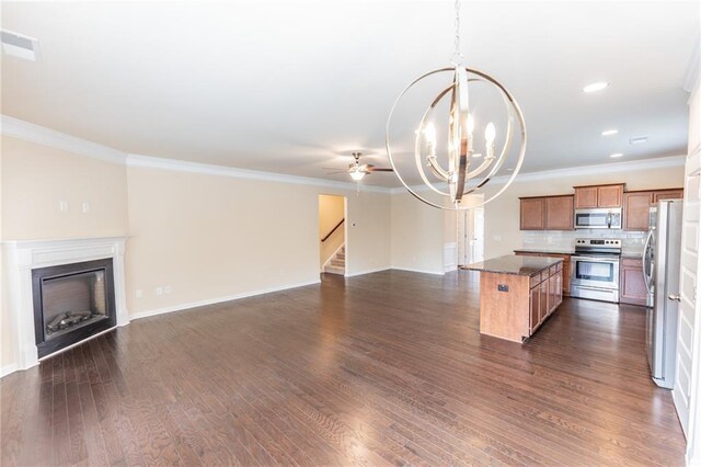 kitchen featuring visible vents, appliances with stainless steel finishes, open floor plan, a center island, and a fireplace