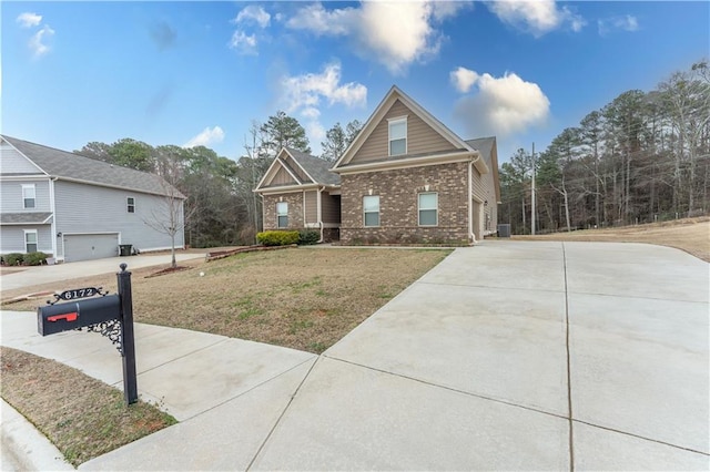 view of front of house featuring concrete driveway, brick siding, and a front lawn