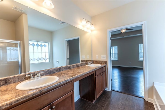 full bath featuring double vanity, wood finished floors, a sink, and visible vents