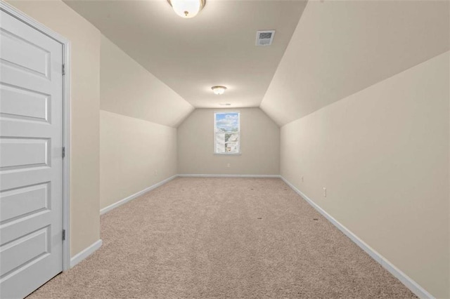 bonus room with light carpet, baseboards, visible vents, and vaulted ceiling