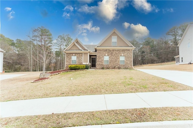 view of front of home with concrete driveway, brick siding, and a front lawn