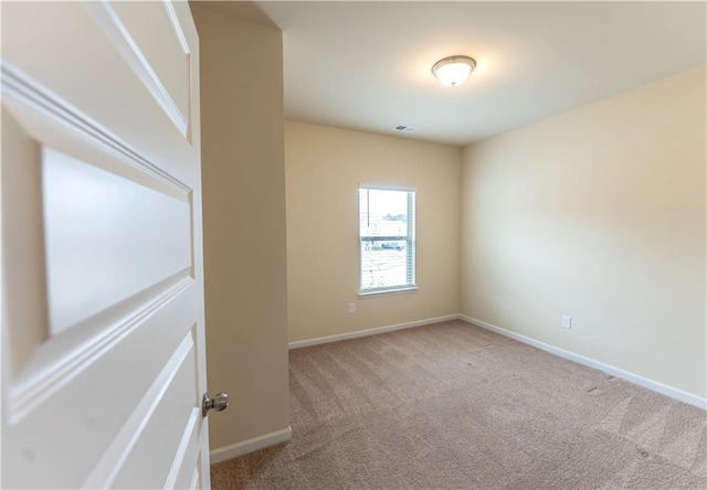 spare room with carpet, visible vents, and baseboards