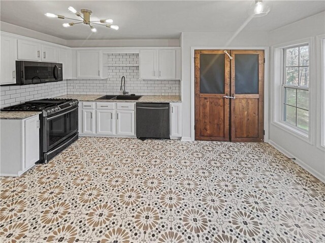 31 Mariner Way SE, Acworth, GA 30102 - kitchen with black dishwasher, light floors, white cabinetry, a sink, and stainless steel gas range