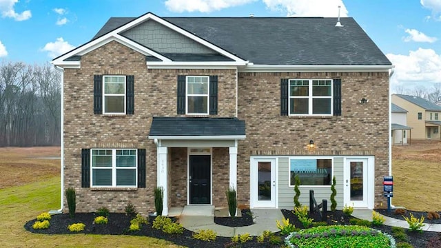 view of front of property featuring brick siding and a front lawn