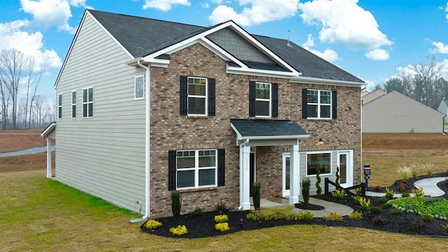 view of front of home with brick siding and a front yard