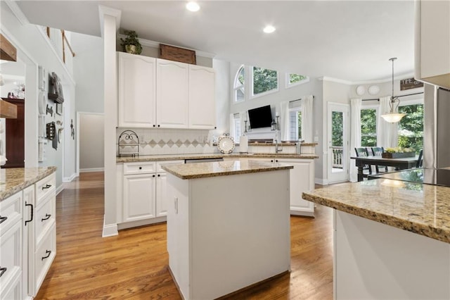 2713 Misty Rock Cv, Dacula, GA 30019 - kitchen with a kitchen island, light wood-type flooring, backsplash, white cabinetry, and recessed lighting