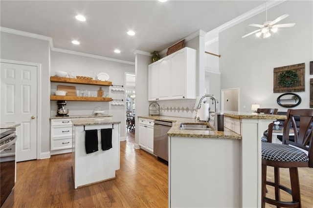 2713 Misty Rock Cv, Dacula, GA 30019 - kitchen with stainless steel appliances, ornamental molding, a breakfast bar, white cabinetry, and light stone counters