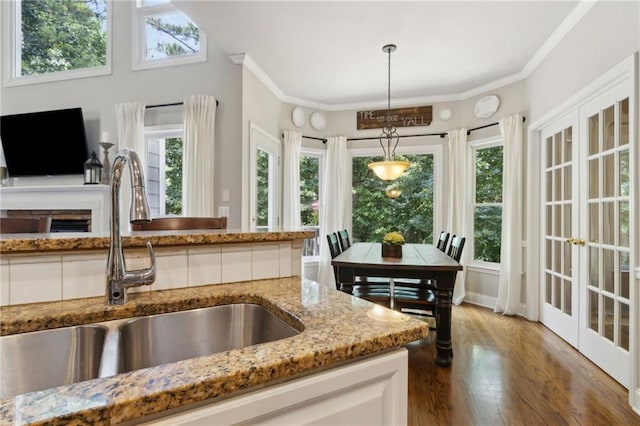 2713 Misty Rock Cv, Dacula, GA 30019 - kitchen featuring light stone countertops, wood finished floors, plenty of natural light, and ornamental molding