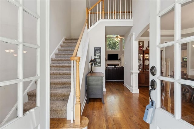 2713 Misty Rock Cv, Dacula, GA 30019 - foyer entrance featuring wood finished floors, stairway, arched walkways, a high ceiling, and decorative columns