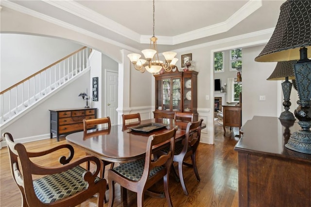 2713 Misty Rock Cv, Dacula, GA 30019 - dining area with hardwood / wood-style flooring, a raised ceiling, stairs, a chandelier, and arched walkways