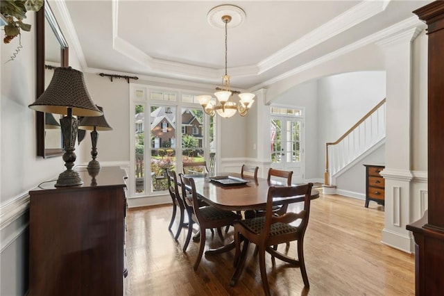 2713 Misty Rock Cv, Dacula, GA 30019 - dining area featuring a chandelier, wainscoting, stairway, light wood finished floors, and a raised ceiling