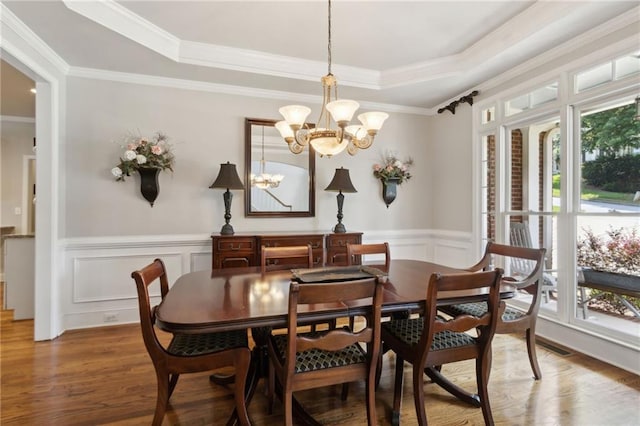 2713 Misty Rock Cv, Dacula, GA 30019 - dining room featuring plenty of natural light, a chandelier, wood finished floors, a wainscoted wall, and a raised ceiling
