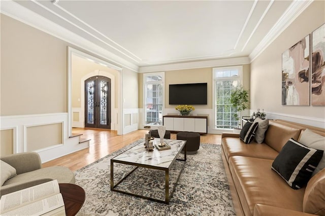 living room featuring french doors, light hardwood / wood-style floors, and ornamental molding