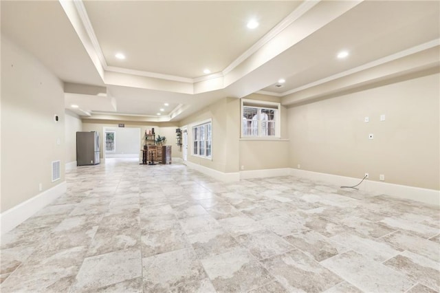 unfurnished living room with a raised ceiling and crown molding