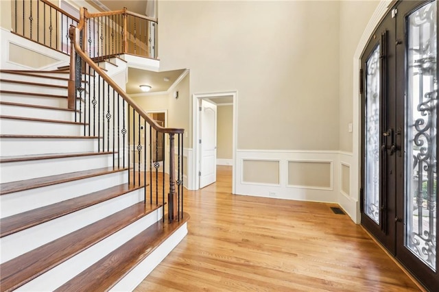 entrance foyer with french doors and light hardwood / wood-style flooring