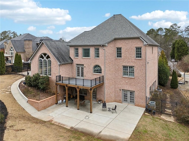 rear view of property with central AC unit, a deck, a patio, and french doors