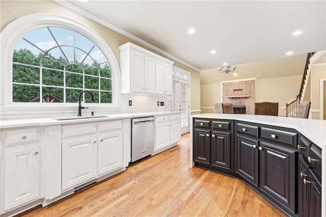 kitchen with dishwasher, sink, light hardwood / wood-style floors, white cabinets, and ornamental molding