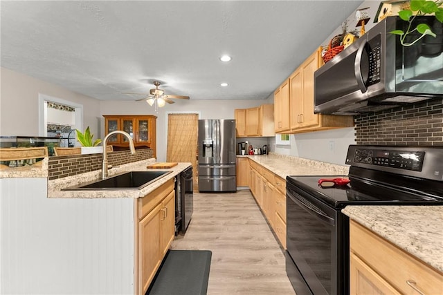 kitchen with light hardwood / wood-style floors, black appliances, decorative backsplash, sink, and light brown cabinetry