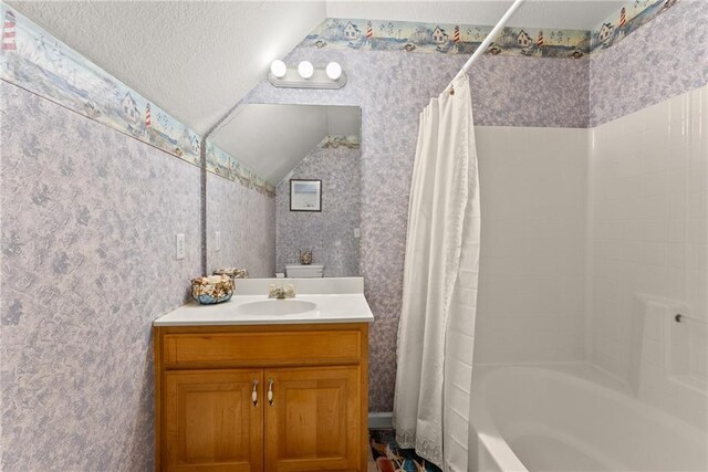 bathroom featuring vanity, vaulted ceiling, and shower / tub combo with curtain