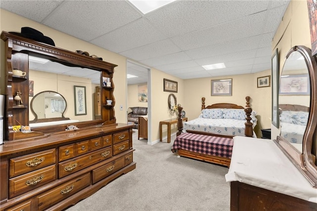 carpeted bedroom featuring a drop ceiling