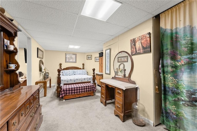 bedroom featuring light carpet and a drop ceiling