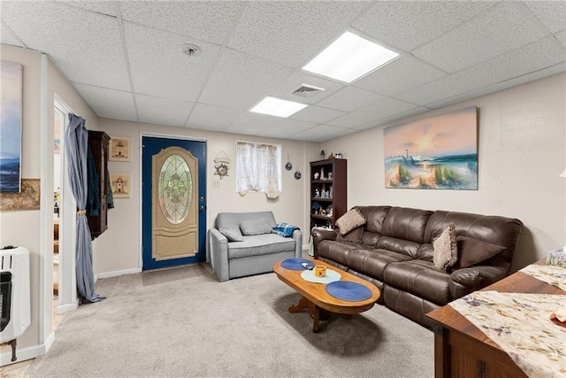 carpeted living room featuring a paneled ceiling and heating unit