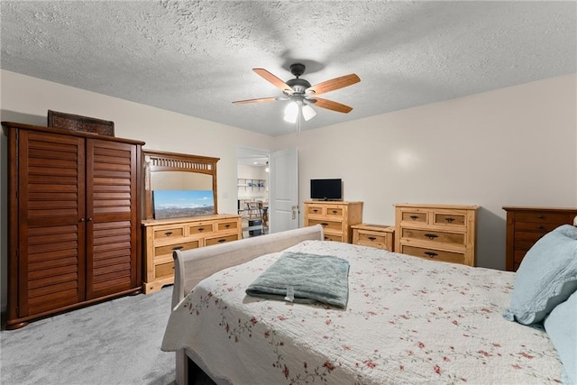 bedroom featuring ceiling fan, a textured ceiling, and carpet flooring