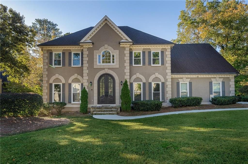 view of front of home with a front yard and french doors