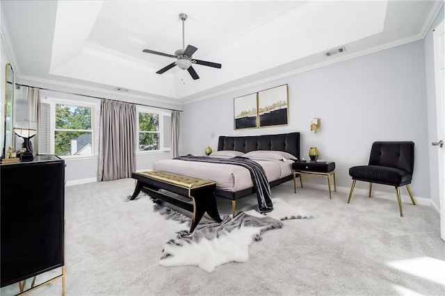 carpeted bedroom featuring ornamental molding, a tray ceiling, and ceiling fan