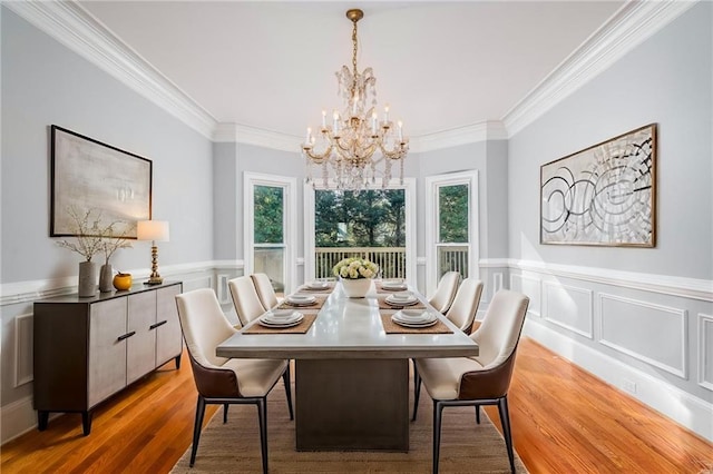 dining area featuring ornamental molding, plenty of natural light, and light wood-type flooring