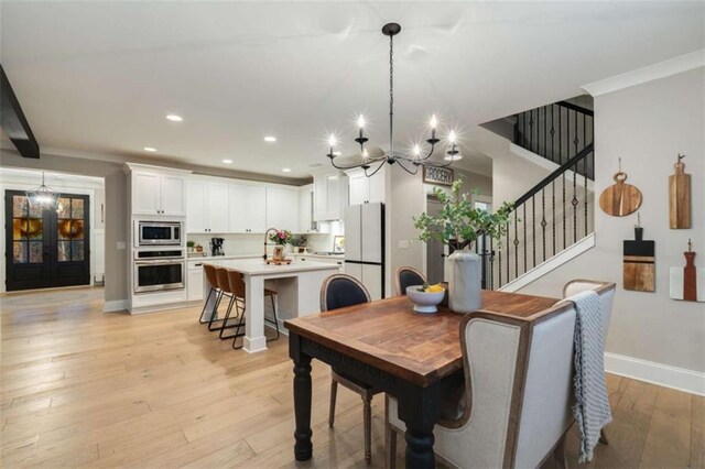 811 Walnut River Trl, Hoschton, GA 30548 - dining area with an inviting chandelier, light wood-style floors, recessed lighting, baseboards, and stairway