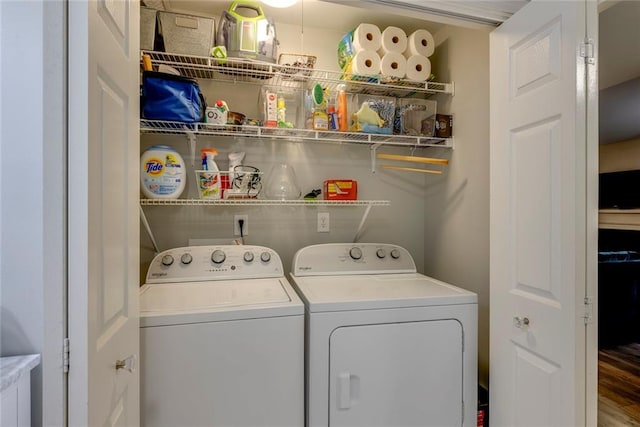 clothes washing area with hardwood / wood-style floors and washer and dryer