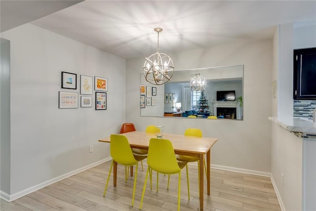 dining room with light hardwood / wood-style flooring and an inviting chandelier