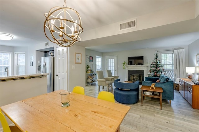 dining room featuring a chandelier, light hardwood / wood-style floors, and sink