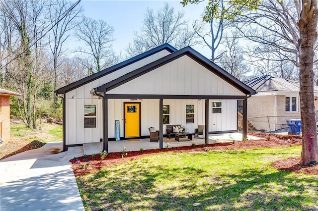 modern inspired farmhouse with a front lawn, an outdoor hangout area, board and batten siding, and a patio