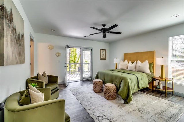 bedroom with a ceiling fan, access to exterior, wood finished floors, and baseboards