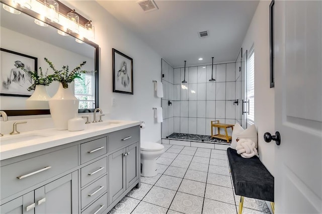 bathroom with double vanity, visible vents, toilet, and a sink