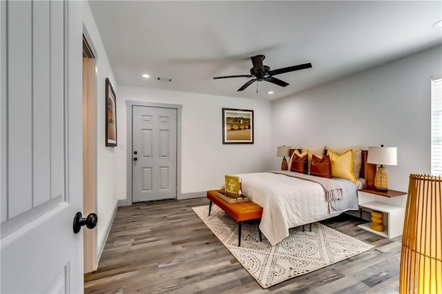 bedroom with recessed lighting, wood finished floors, visible vents, and baseboards