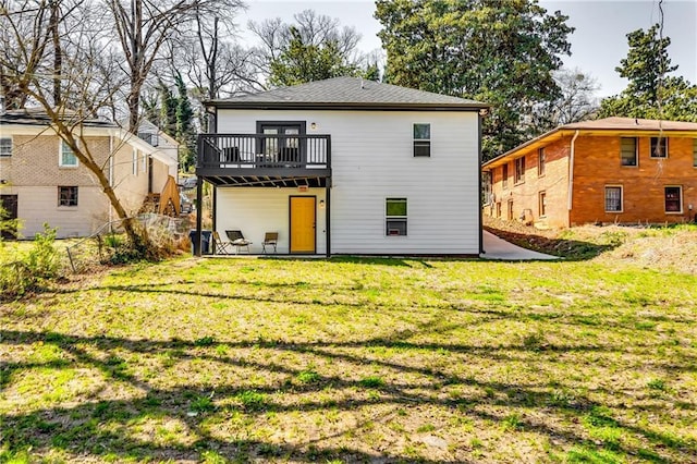 rear view of property featuring a yard and a deck