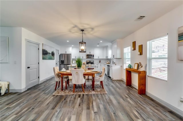 dining space featuring dark wood-type flooring, recessed lighting, baseboards, and visible vents