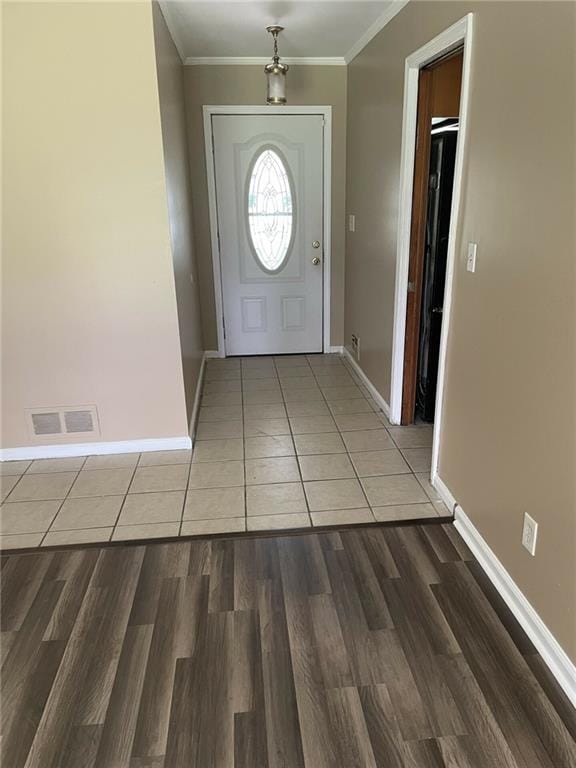 foyer entrance featuring wood-type flooring and crown molding