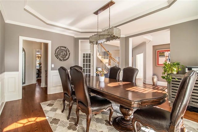 dining space with crown molding, dark hardwood / wood-style flooring, and a tray ceiling