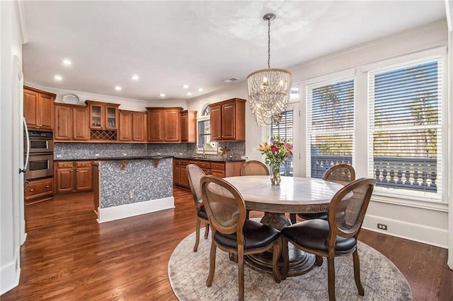 dining room featuring ornamental molding, dark hardwood / wood-style floors, and a notable chandelier