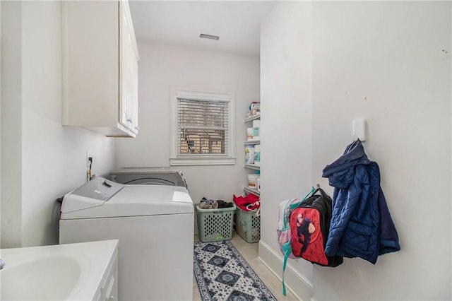 clothes washing area featuring cabinets, washer and dryer, and sink