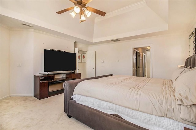 bedroom with ornamental molding, light colored carpet, ceiling fan, and a tray ceiling